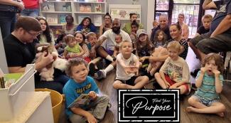 kids and adults sitting on the floor in a book store or library