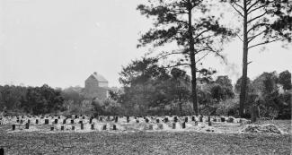 Black and white photo of graves in a field.