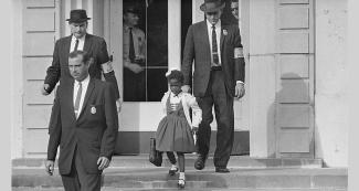 Ruby Bridges walking down school steps with US Marshals