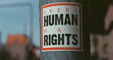 Urban street art sticker on metal pole says "Every Human Has Rights"