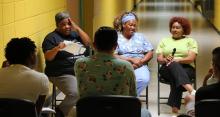 Students and Elaine, AR residents seated in a circle in a hallway recording oral histories.