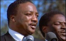 Paul Winfield as Martin Luther King Jr. stands speaking at a microphone